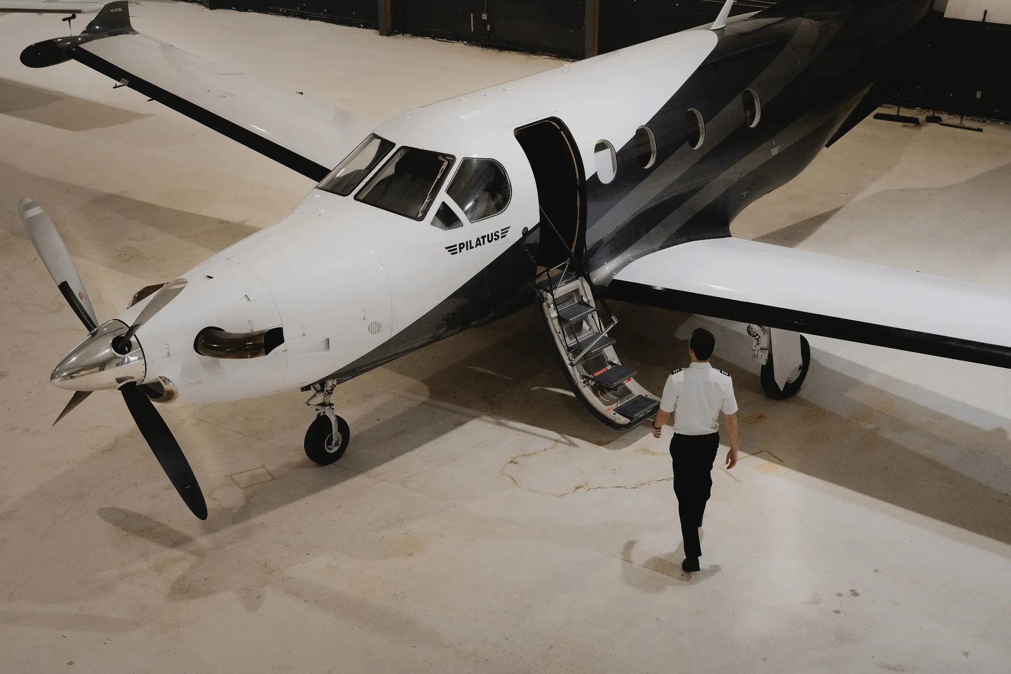 Employé s’apprêtant à monter dans un avion dans un hangar.