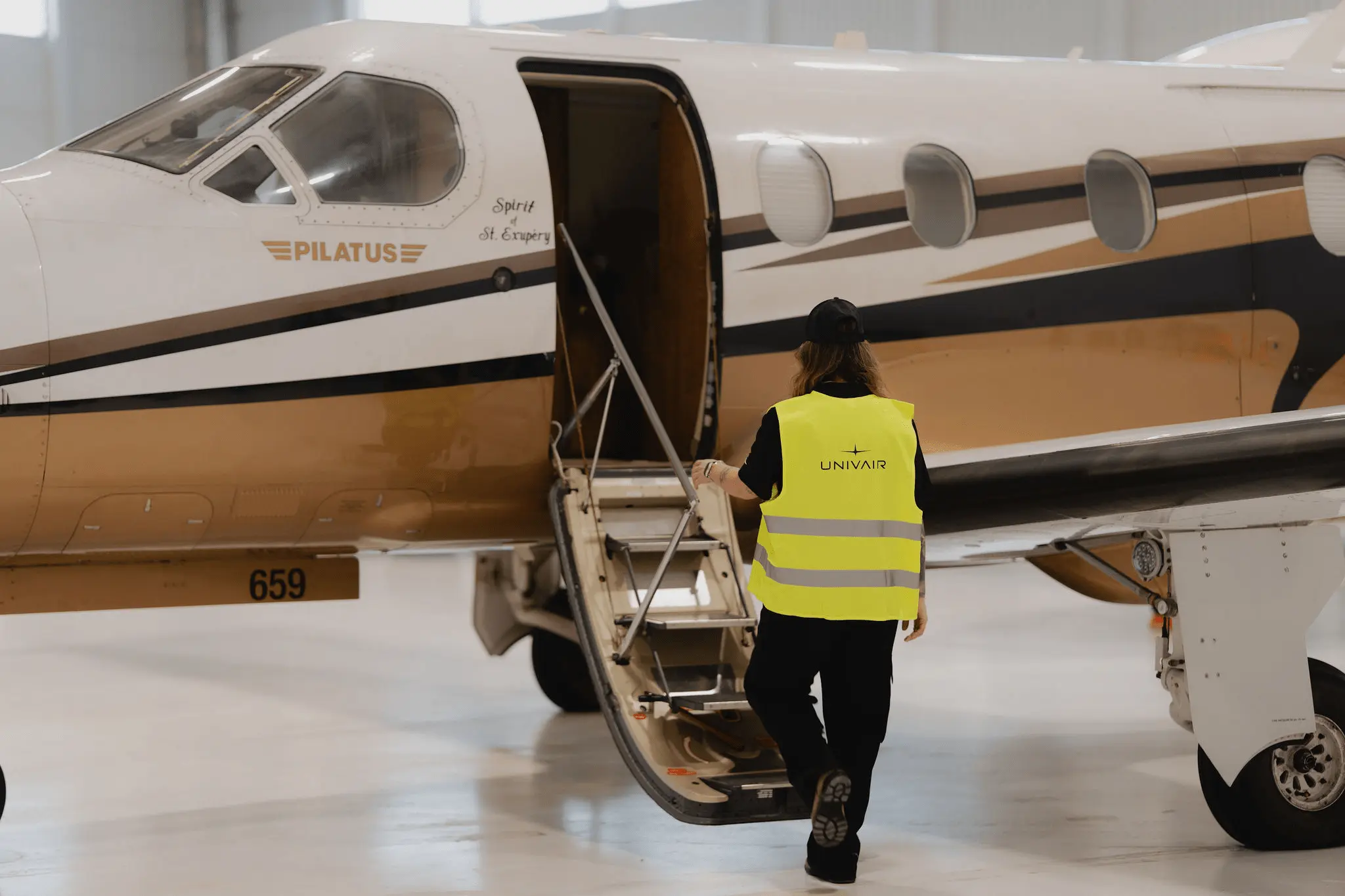 Employé s’apprêtant à monter dans un avion dans un hangar 