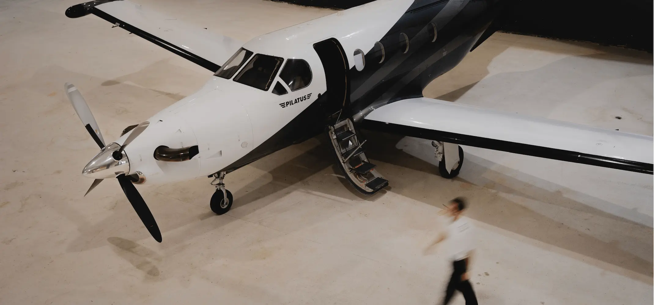 Personne marchant dans un hangar d’aviation vers un avion stationné