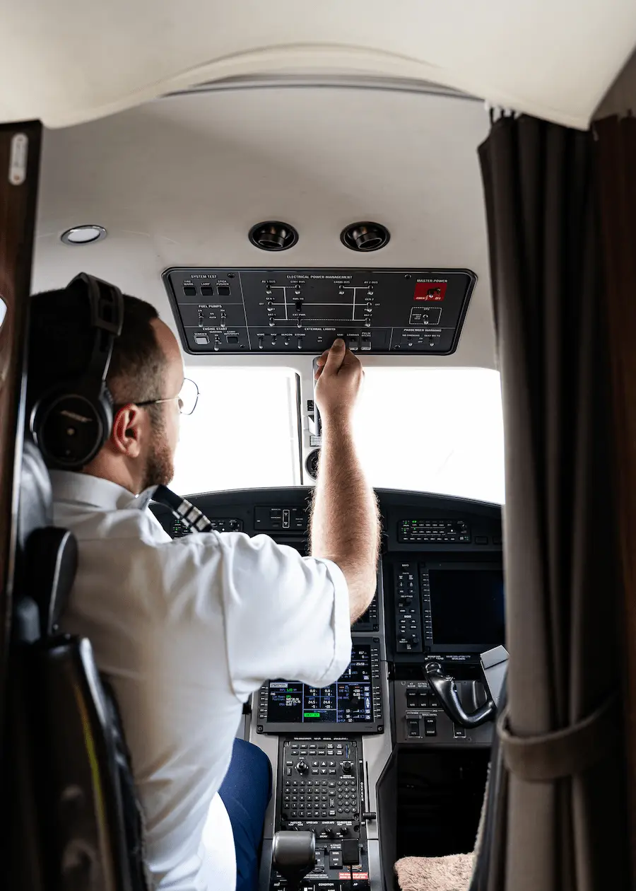 Un pilote dans une cabine qui manipule des boutons de contrôle