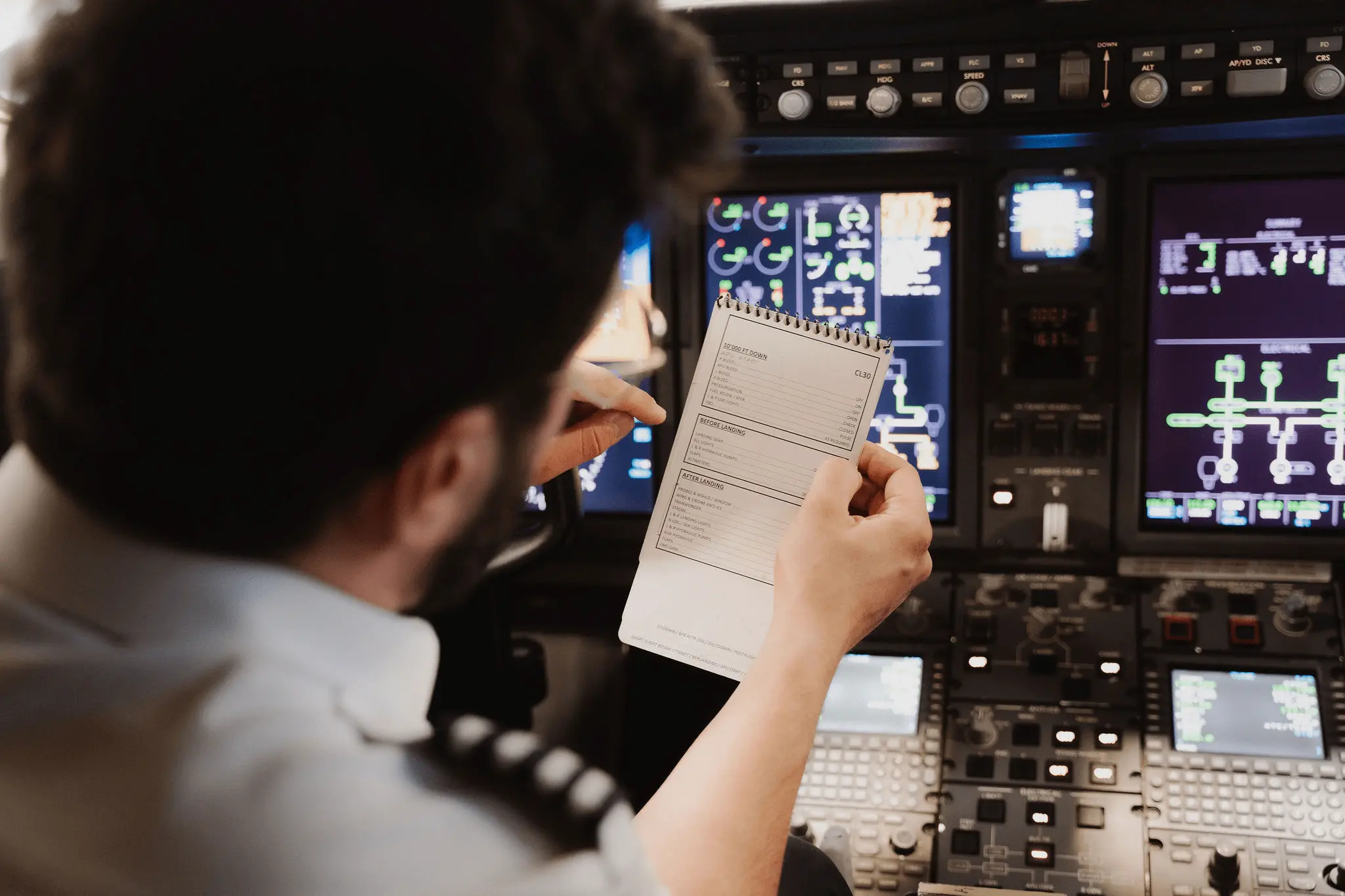 Pilote dans le cockpit consultant une fiche de vol